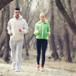 Two young people jogging in a park